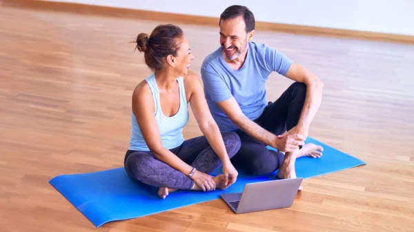 Pareja haciendo yoga y riendo